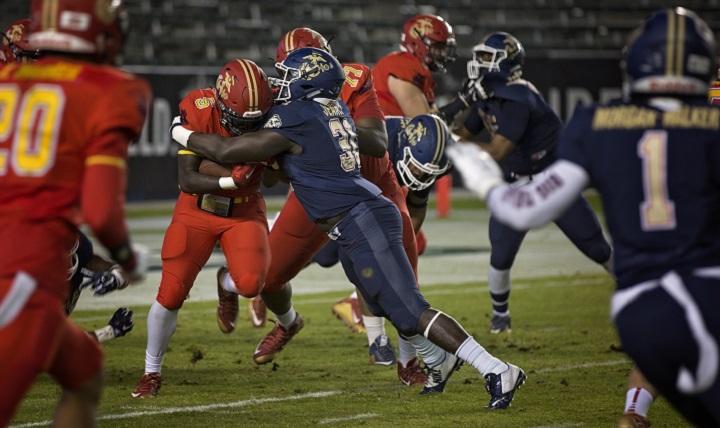 Dallas Jeanty blocks D’Vaughn Pennamon during the Semper Fidelis All-American Bowl at the Stubhub Center, Carson, Calif., Jan. 3, 2016. High school athletes chosen to play in the Semper Fidelis All-American Bowl are well-rounded individuals on and off the field who not only are distinguished athletes, but also have academic achievements and display exemplary moral character. Jeanty is an outside linebacker from Fort Lauderdale High School, Fort Lauderdale, Fla., and Pennamon is a running back from Manvel High School, Manvel, Texas. (U.S. Marine Corps photo by Sgt. Rebecca Eller)