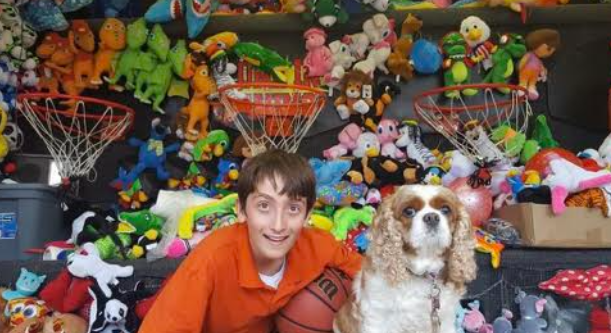 Joey and his dog Lucy posing in front of a carnival game in 2017.
