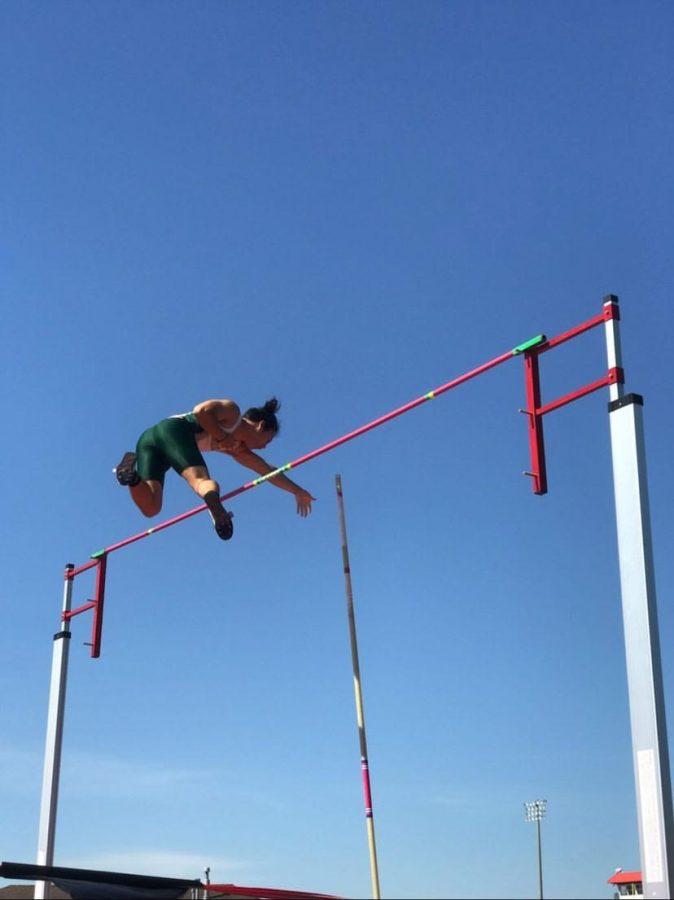 Ethan You clearing over a bar, pushing his pole away mid air.