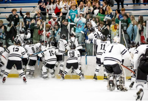 The Panther hockey team celebrates a recent win with members of the Black Hole.