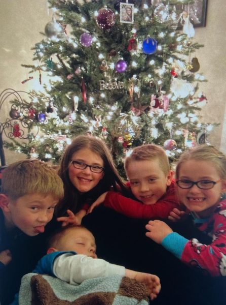 Eden Hamltion and her family friends under the Christmas tree