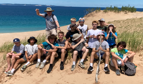 Coach Chris Knoll joins the cross country team on a summer retreat at Lake Michigan.