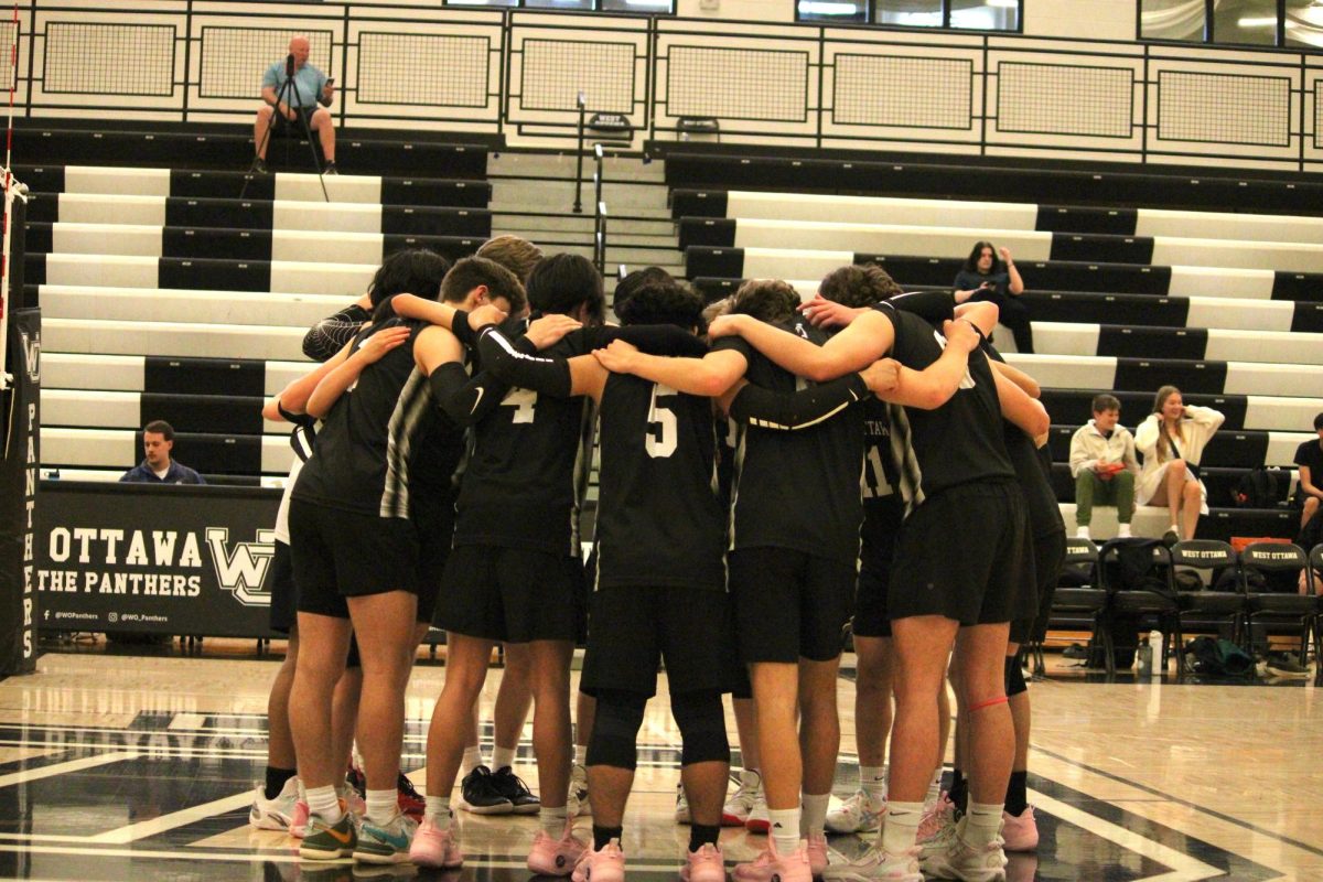 The boys' varisty volleyball team coming together before their match against Grand Haven. 